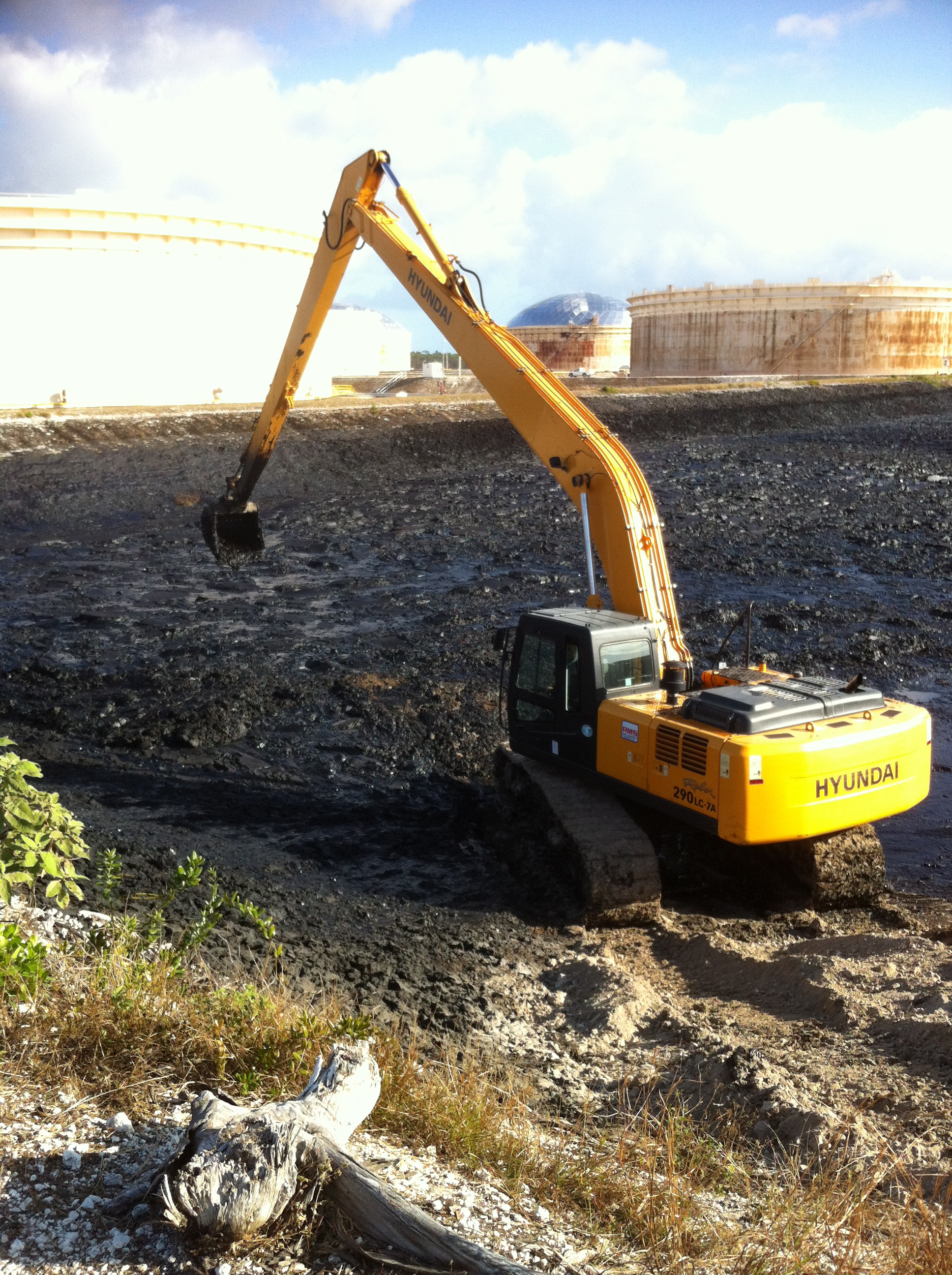 Excavator removing oil sludge at the South Riding Point Terminal